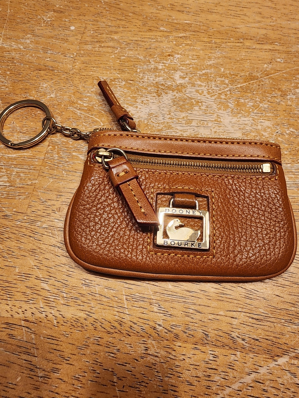 Dooney & Bourke Pebble Grain Small Coin Case in a tan/caramel color finish